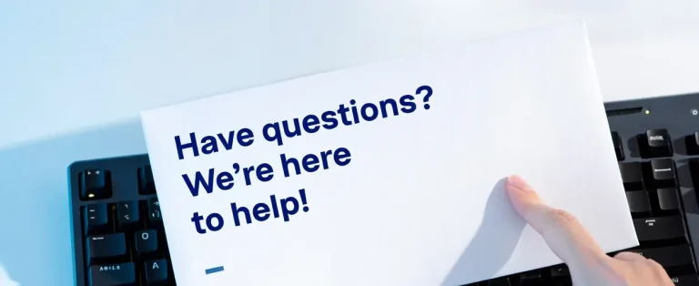 support link Hand holding a card that reads, "Have questions? We're here to help!"